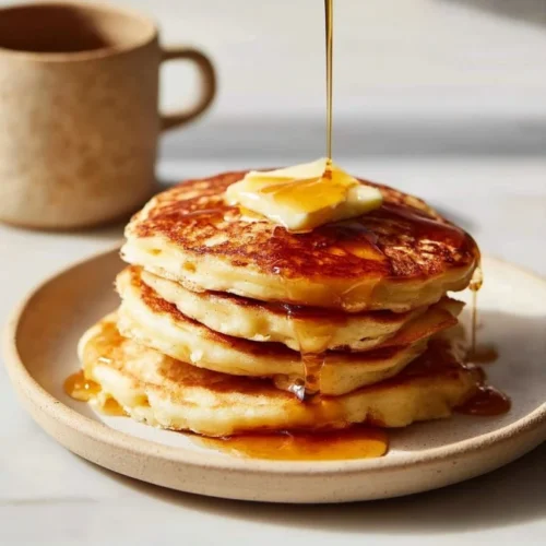 Fluffy oatmeal pancakes topped with fresh berries and maple syrup