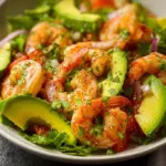 Fresh Shrimp Avocado Salad with greens, tomatoes, and dressing