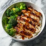Delicious Sticky Chicken Bowl garnished with green onions and sesame seeds