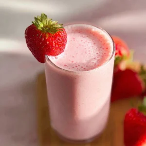 Delicious strawberry yogurt smoothie in a clear glass with fresh strawberries
