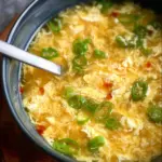 Bowl of delicious Egg Drop Soup with green onions and a sprinkle of pepper