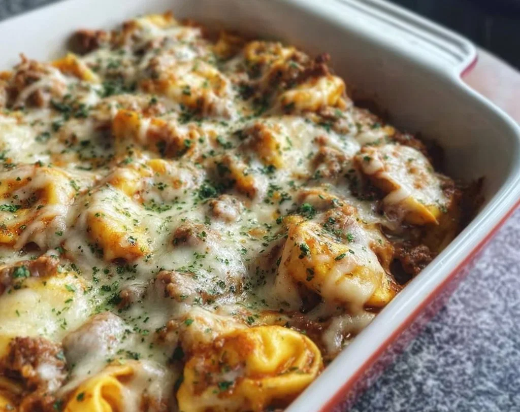 Italian Sausage Tortellini Bake garnished with herbs and cheese in a baking dish