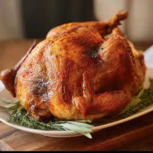 Air fried whole turkey on a serving platter with garnishes