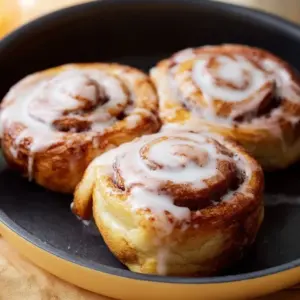 Delicious air fryer cinnamon rolls topped with icing.