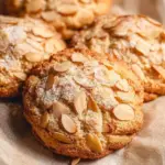 Freshly baked almond croissant cookies with a golden crust and almond topping.