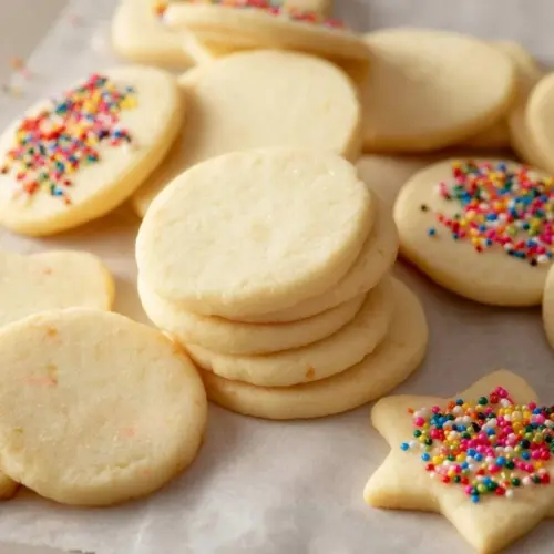 Delicious cream cheese sugar cookies on a plate with sprinkles