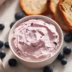 Delicious blueberry cream cheese spread on a bagel with fresh blueberries
