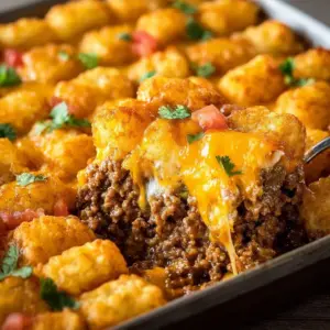 Cheesy beef tater tot casserole served in a baking dish