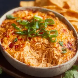 Delicious Spicy Chicken Dip served in a bowl with tortilla chips.