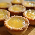 Lemon Bar Cookie Cups served on a white plate, showcasing their vibrant yellow filling.
