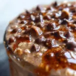 Bowl of mocha overnight oats topped with chocolate and coffee beans