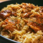 Plate of oven-baked chicken served with rice and fresh herbs