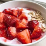 Delicious strawberry yogurt bowl topped with fresh strawberries and granola.