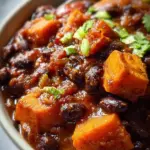 Bowl of Sweet Potato Black Bean Chili topped with fresh herbs