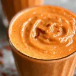 Delicious carrot cake smoothie topped with whipped cream and cinnamon.