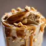 Peanut Butter Banana Protein Shake in a glass with a banana and peanut butter